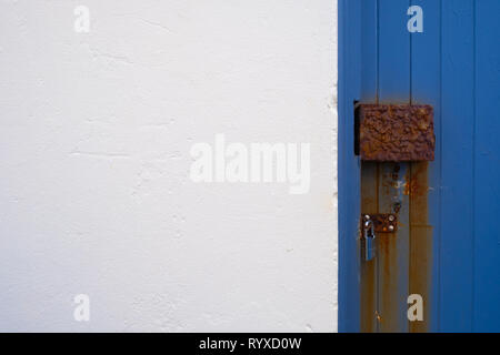 Rusted door lock on blue door with copy space on the left Stock Photo