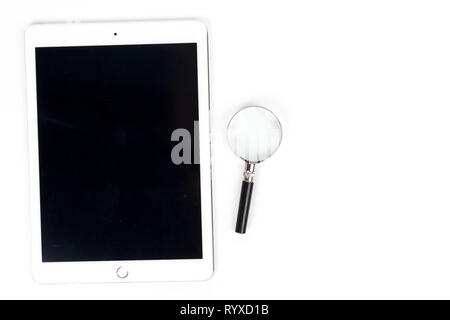 workspace top view The tablet,Magnifying glass is placed on a white desk in the office concept Stock Photo
