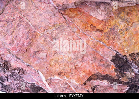 Stone texture background with unique pattern. Pink, red, black rock texture. Rock surface abstract background. Natural stone background. Purple rough  Stock Photo