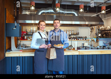 Catering service and home delivery with small restaurant owners holding to go food Stock Photo