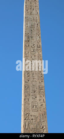 Ancient Egyptian obelisk with hieroglyphics and blue sky background Stock Photo