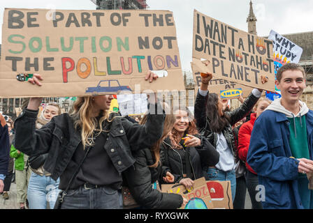 London, UK. 15th March, 2019. School students campaigning against climate change protest outside Parliament. Credit: Maggie sully/Alamy Live News. School children on strike to protest at climate change gathering outside Parliament, London. The students, boys and girls, smile and shout and carry colourful homemade banners "Be part of the solution not the pollution", and "I want a hot date not a hot planet". Part of the worldwide 'FridaysforFuture' protest. Stock Photo