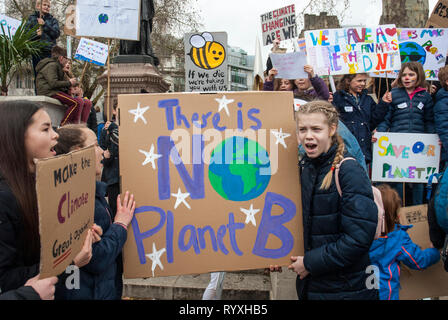 London, UK. 15th March, 2019. School students campaigning against climate change protest outside Parliament. Credit: Maggie sully/Alamy Live News. School children on strike, part of the 'FridaysforFuture' protest against climate change gather outside Parliament, London. Girls shouting slogans about planet justice and global warming carrying a colourful placard 'There is no planet B' with others posters in the background including one with a yellow stripey bee 'If we die we are taking you with us' and 'Save the planet'. Stock Photo