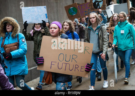Chicago, USA. 15th Mar, 2019. As part of the world wide 'Youth Climate Strike' a spirited group of Chicago area young folks left their schools this morning, gathered near the Field Museum and marched through Grant Park to Federal Plaza in the loop, chanting their commitment to ending the threat of climate change. In the plaza, young speakers, mostly students from area high schools, exhorted the crowd to hold the government accountable by 'registering to vote, showing up at the polls, and voting them out'  if elected officials deny that climate change is a threat. Credit: Matthew Kaplan/Alamy L