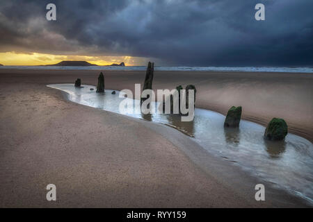 Dramatic sunset at Worms Head and Rhossili Bay Stock Photo