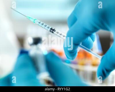 Doctor preparing a dose of medicine to give to a patient. Stock Photo