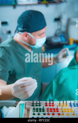 Dentist installing dental implant. Stock Photo