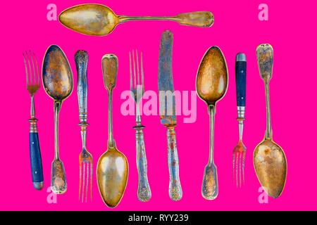 Vintage cutlery on a plastic pink background. Top view. Crazy concept for culinary and modern life. Contrast between shabby cutlery and excellent mode Stock Photo