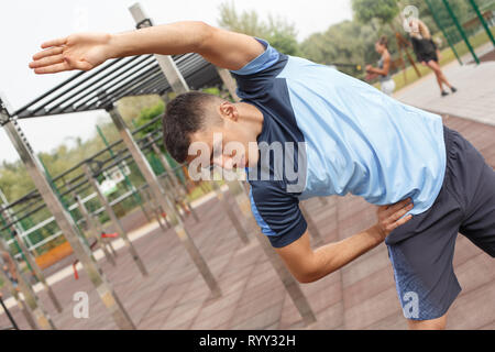 Healthy Lifestyle. Young man exercising outdoors leaning to the right thoughtful close-up Stock Photo