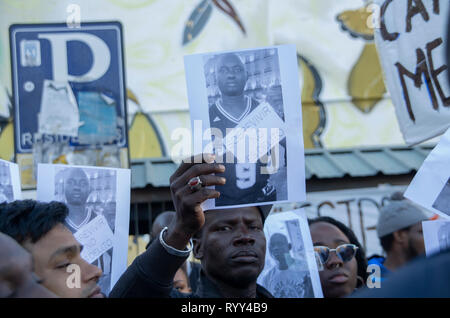 Demonstrators seen with the portrait of Mame Mbaye during the protest. Protest against institutional racism took place at Nelson Mandela square in Madrid one year after the death of Mame Mbaye, a Senegalese street vendor who died while being chased by the police for selling on the streets. According to the demonstrators, the young man did not have any legal papers despite having spent more than 10 years in Spain and authorities did not help his family after his death. They also paid homage to the victims of the New Zeland terrorist attack in mosques. Stock Photo