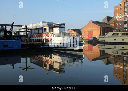 Tourist trip boats moored in Gloucester Docks in brigt sunlight and calm water with reflections Stock Photo