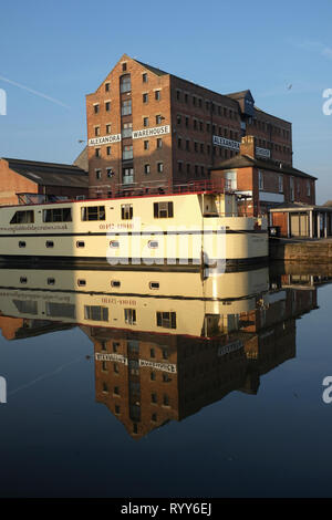 Tourist trip boats moored in Gloucester Docks in brigt sunlight and calm water with reflections Stock Photo