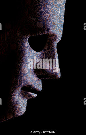 Robot face mask side view close up with textured skin and blank eyes. Black background and space for text. Artificial intelligence concept in a human  Stock Photo