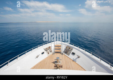 View over the bow of a large luxury motor yacht on tropical open ocean with anchors Stock Photo