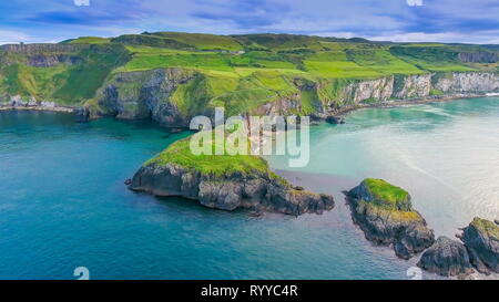 Landscape view of the Carrick-a-Rede Rope Bridge with the big ocean fronting the mountain cliff in Ireland in Ireland Stock Photo