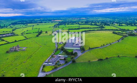 Aerial landscape view of the whole city seen the green fields trees and residential houses on a blue sky with white clouds in Ireland