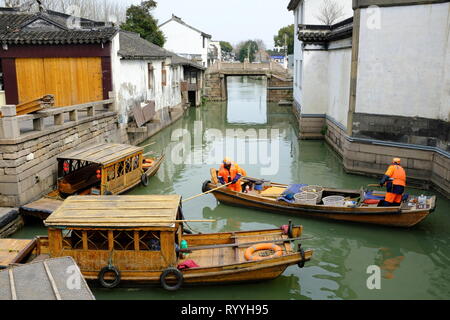 Sanitation workers in wooden cleaning boat cleaning the Suzhou canal. Suzhou.Jiangsu province.China Stock Photo