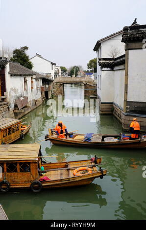 Sanitation workers in wooden cleaning boat cleaning the Suzhou canal. Suzhou.Jiangsu province.China Stock Photo