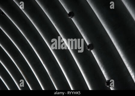 metal interior of the tunnel, abstract detail with diagonal dark and bright lines, monochrome texture; metal waves background Stock Photo
