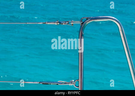 sailboat handrail in the caribbean. metal handrail against crystal clear caribbean water Stock Photo