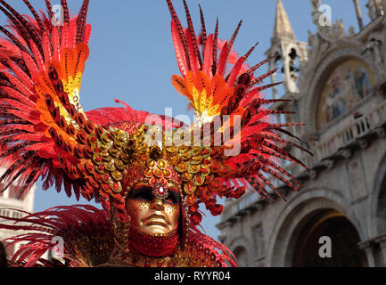 Man dressed in traditional mask and costume for Venice Carnival standing in Piazza San Marco in front of Saint Mark's Basilica, Venice, Veneto, Italy Stock Photo