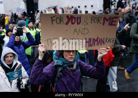 Brussels, Belgium. 15th Mar, 2019. A woman holding a placard takes part in a demonstration against climate change in Brussels, Belgium, March 15, 2019. Thousands of school students across Belgium abandoned classrooms for a day of climate demonstrations on Friday as part of the 'Global Strike for Future', local press reported. Credit: Zhang Cheng/Xinhua/Alamy Live News Stock Photo