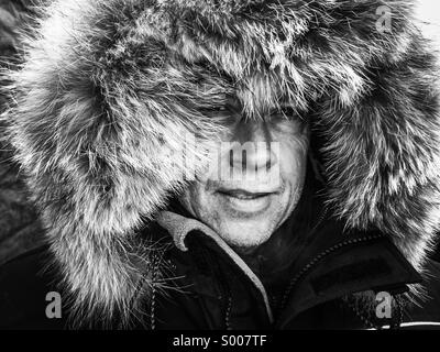 An arctic explorer braces himself against freezing winds and blizzard conditions. Stock Photo