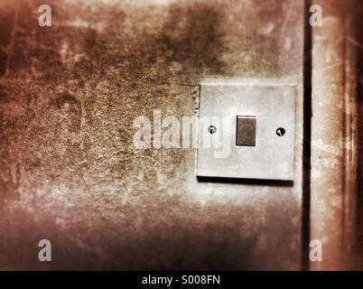 Old dirty light switch turned on Stock Photo