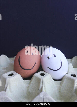 Happy faces, brown and white eggs. Stock Photo