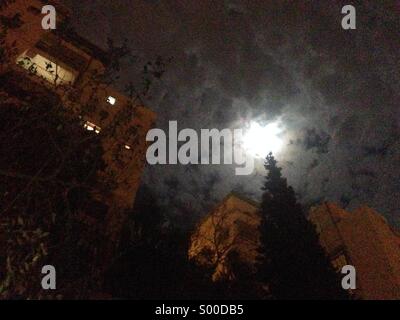 Moon light break in through the clouds of Jerusalem night sky Stock Photo