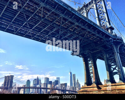 View of the Manhattan and Brooklyn Bridges with Lower Manhattan skyline as seen from the DUMBO neighborhood in Brooklyn, New York.