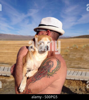 Middle-aged man holding Terrier-Chihuahua dog in Owens Valley area of Mammoth Lakes, California Stock Photo