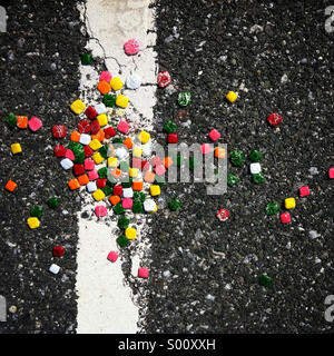 Chiclet candy spilled on an asphalt road in an abstract pattern Stock Photo