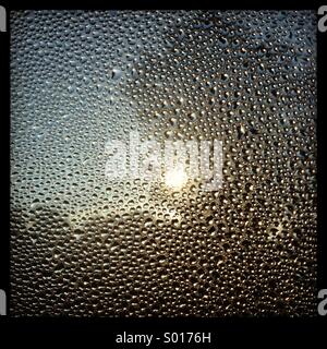 Condensation on a window at sunrise Stock Photo