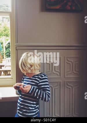 A young boy playing on an iPod Stock Photo