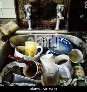 Close up of squalid kitchen sink full of dirty dishes Stock Photo