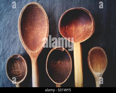 Beautiful old wooden spoons for cooking on a slate background. Stock Photo
