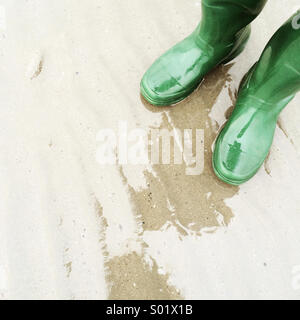 Green wellies on the beach Stock Photo