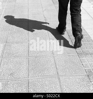 Shadow of a man walking in the street Stock Photo