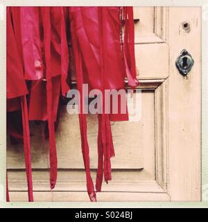 Red costume on old wooden door Stock Photo