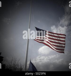 American flag flying at half mast Stock Photo