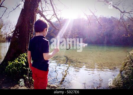 Boy with ice lolly near lake Stock Photo