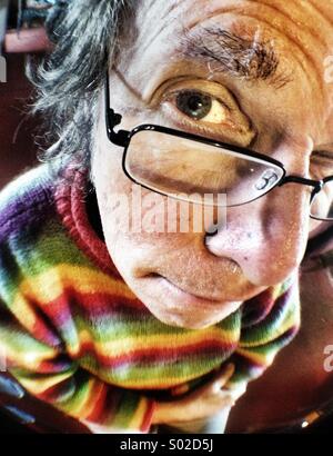 Raised eyebrow, face of mature Caucasian man wearing glasses, wide angle close up Stock Photo