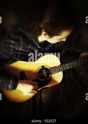 Guitar player, young guy playing acoustic guitar Stock Photo