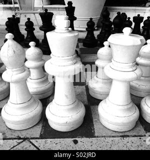 Close up of chess pieces on sidewalk board game Stock Photo