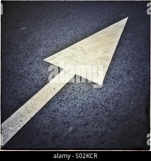 Painted white arrow sign on asphalt Stock Photo