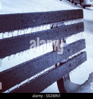 Icicles on park bench in freezing rain and snow Stock Photo