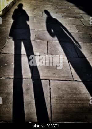 Shadows of two women on the sidewalk Stock Photo - Alamy