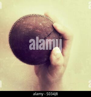 Cricket ball caught in a boys hand Stock Photo