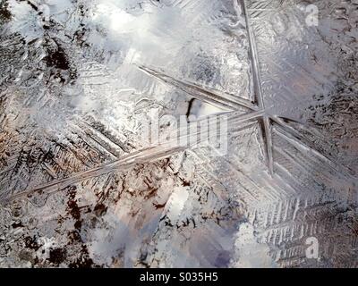 Ice crystal star pattern on the surface of a freezing pond Stock Photo